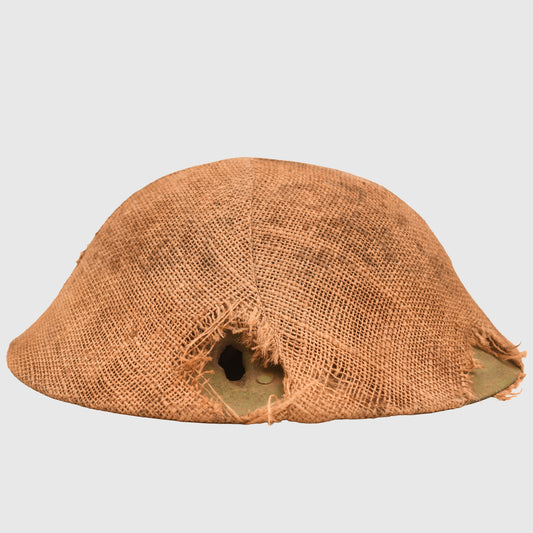 BRITISH WWI VERY FIRST PATTERN BRODIE HELMET IN GREEN WITH BATTLE DAMAGE AND FIELD COVER