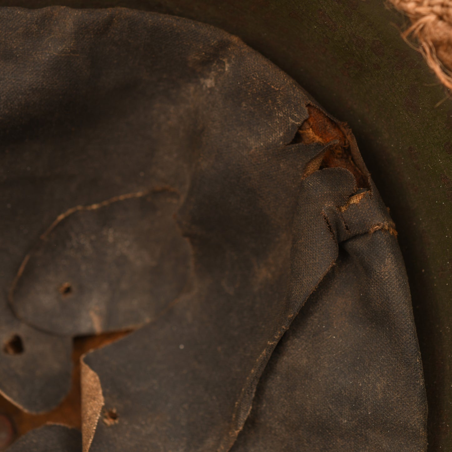 BRITISH WWI VERY FIRST PATTERN BRODIE HELMET IN GREEN WITH BATTLE DAMAGE AND FIELD COVER