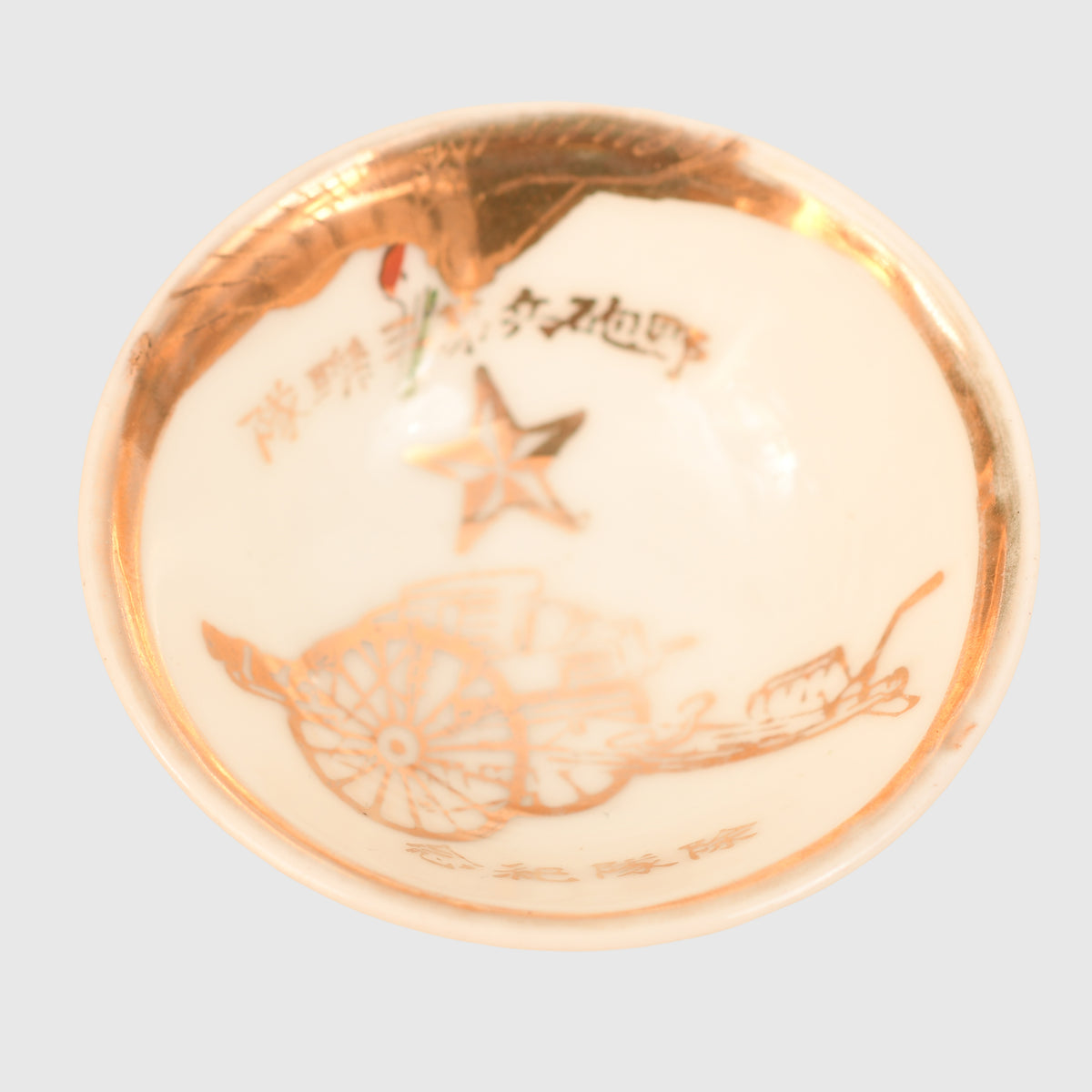 JAPANESE WWII SAKI CUP WITH IMAGES OF A FIELD GUN